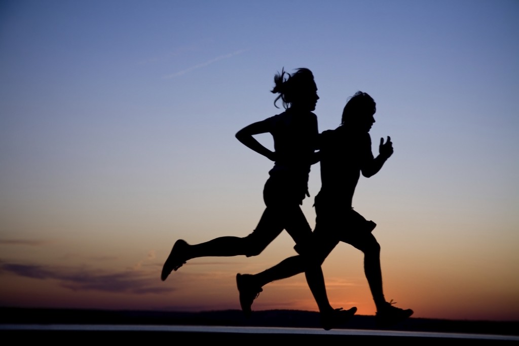 Young couple run together on a sunset